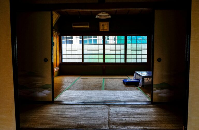 Serene interior of a traditional Japanese ryokan with tatami flooring and sliding doors.
