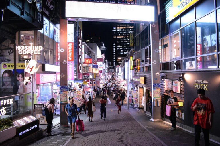 Bustling nightlife on Takeshita Street, Tokyo, showcasing vibrant neon signs and a lively crowd.