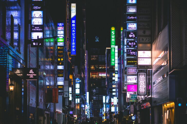 Colorful neon signs illuminate the bustling streets of Ginza, Tokyo at night, capturing urban nightlife.